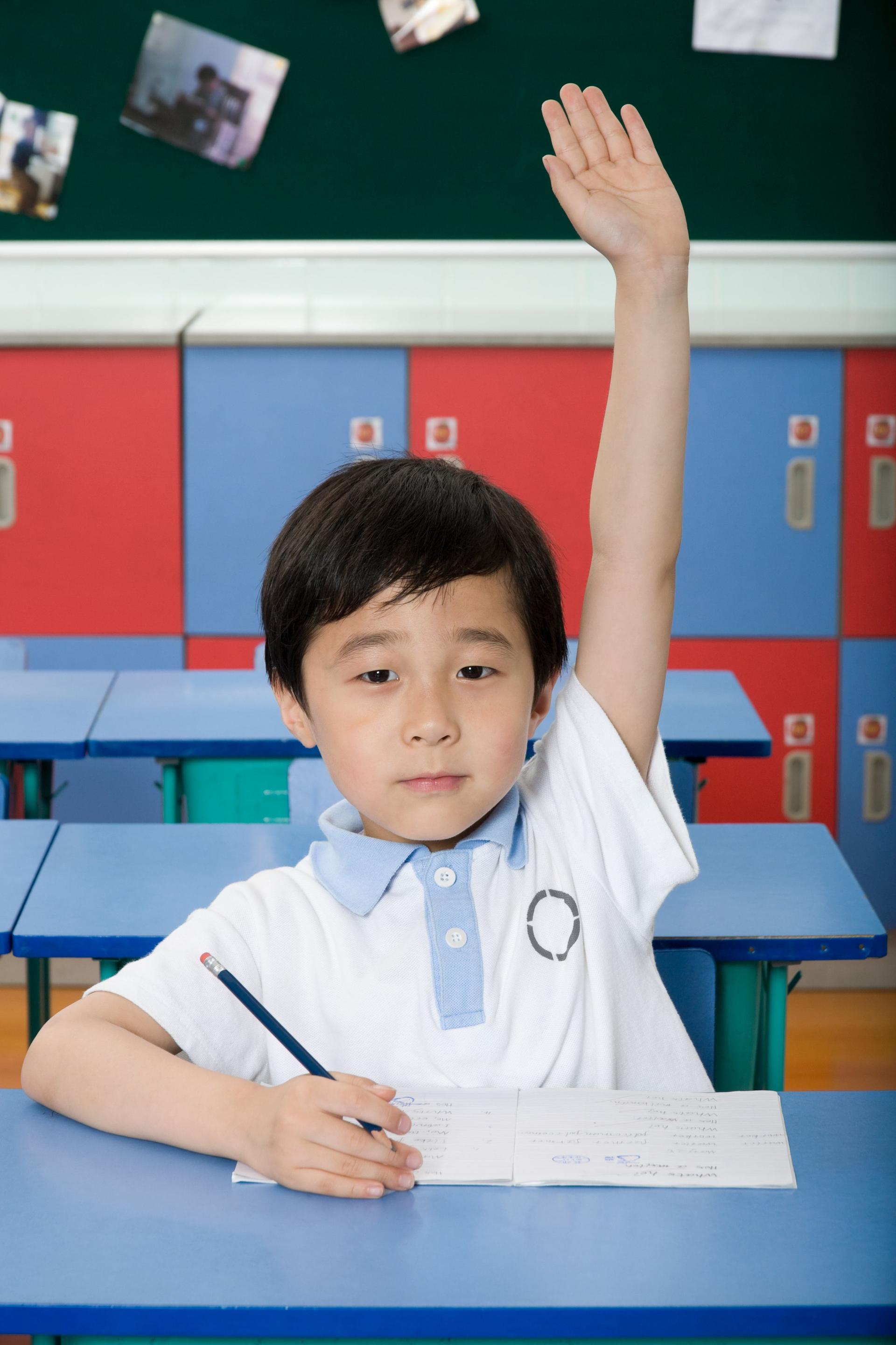 A boy with his hand raised