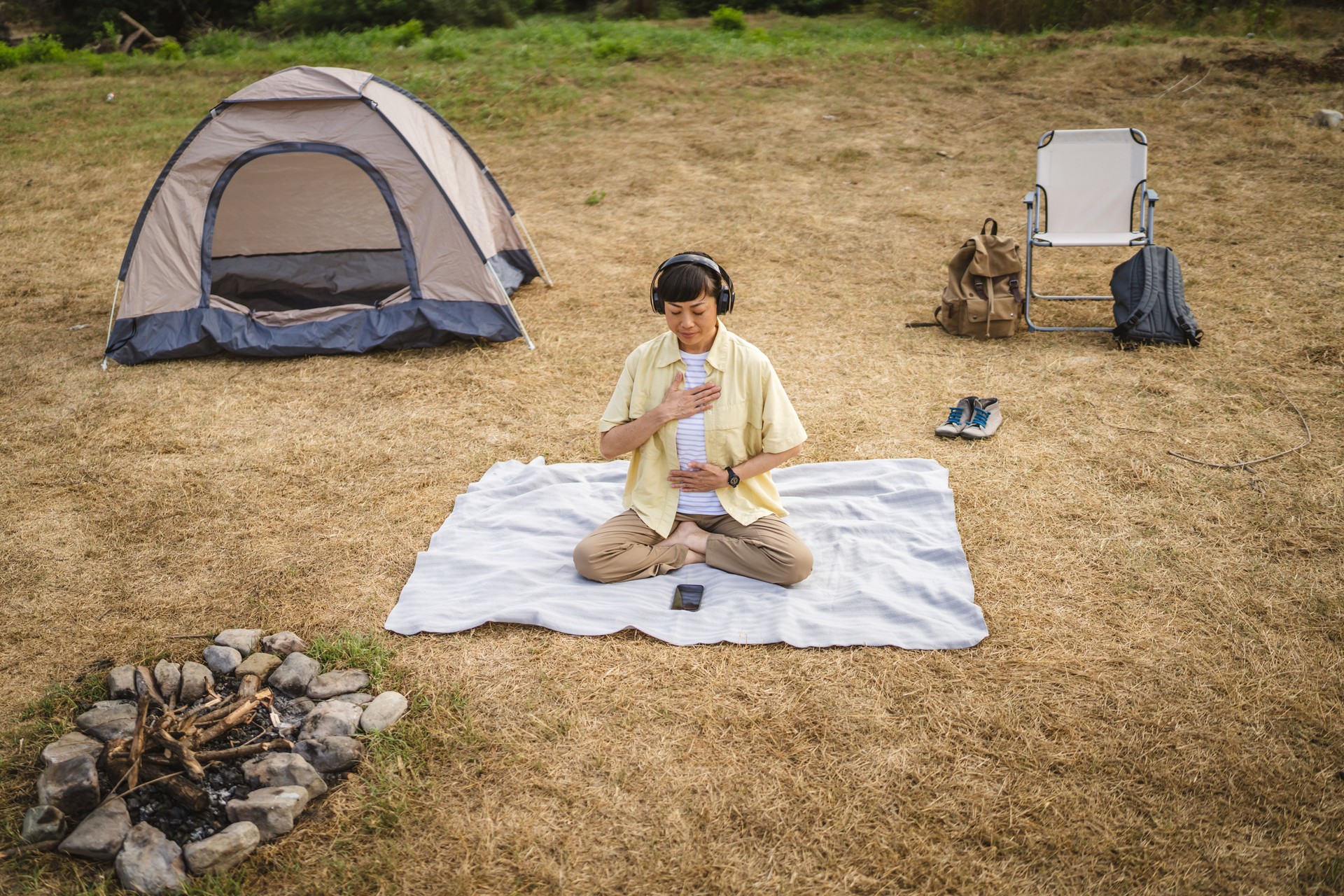 Japanese woman practice guided meditation manifestation in front tent