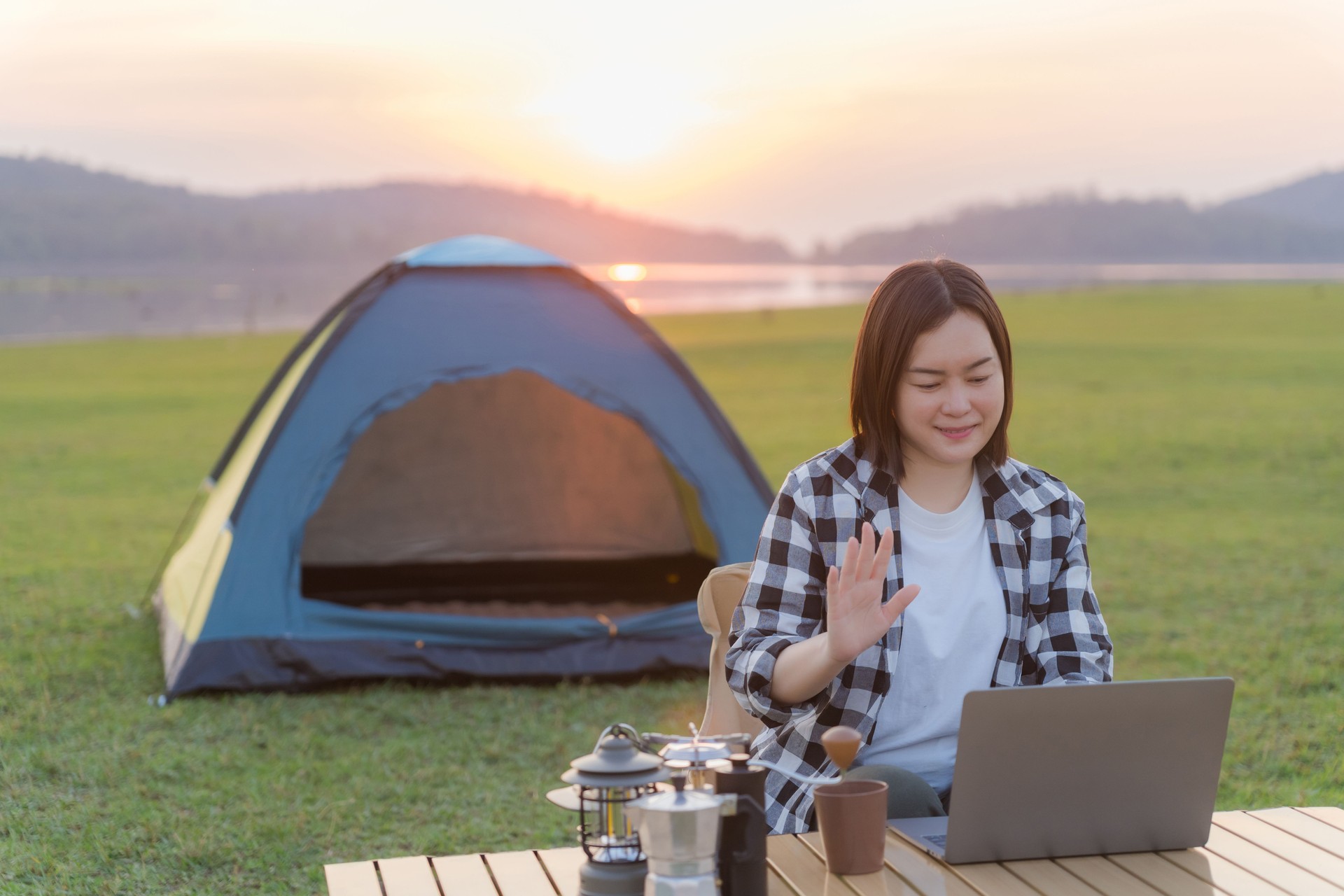 Freelance woman working on laptop while camping outdoors